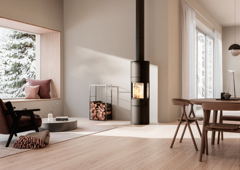 Black, tall wood-burning stove in a dining room setting."